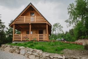 a log cabin with a car parked in front of it at Domek na Groniku in Zubrzyca Górna