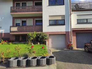 un edificio de apartamentos con un patio con flores rojas en Haus Elena, en Bestwig