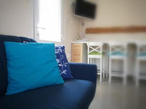 a blue couch with a blue pillow in a living room at Gyöngyszem Vendégház in Eger