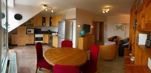 a kitchen with a wooden table and red chairs at Ferienwohnung Panoramablick Ennepetal in Ennepetal