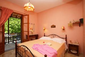 una camera da letto con un letto con un vestito rosa di Irene a Stafylos