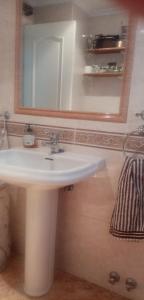 y baño con lavabo blanco y espejo. en Habitación en casa compartida, en Huelva