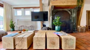 a living room with a tv and a table and a couch at House C in De Haan