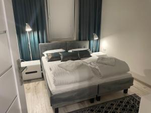 Un dormitorio con una cama grande con almohadas. en Apartamenty Rynek 21, en Muszyna