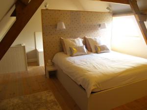 a bedroom with a large bed with a padded headboard at MaMoMa in Sint-Martens-Latem