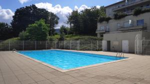 a large blue swimming pool next to a building at L'Olympic in Chalezeule