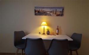 a table with a lamp and a bottle of wine on it at Apartament z pięknymi widokami, około 900m do przejrzystego jeziora Choczewskiego, blisko morza in Perlino