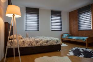 een slaapkamer met een bed en een lamp bij Prva Apartment in Novi Pazar