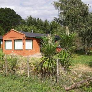 an orange house with a fence in front of it at Complejo Don Bosco in Tandil