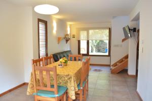 a dining room and living room with a table and chairs at La Araucaria in Villa La Angostura