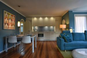 ein Wohnzimmer mit einem blauen Sofa und einer Küche in der Unterkunft Haus Lene in Wyk auf Föhr