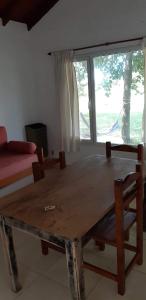 a wooden table in a living room with a large window at Complejo Don Bosco in Tandil