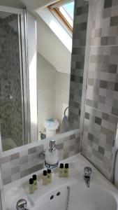 La salle de bains est pourvue d'un lavabo et d'un miroir. dans l'établissement Lios Éinne House Accommodation, à Inis Oírr