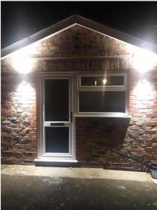 a brick house with two windows at night at The Bungaloaf in Walton on the Hill