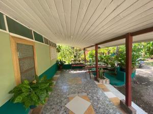 une terrasse couverte d'une maison avec une table et des bancs dans l'établissement Coco verde, à Coco