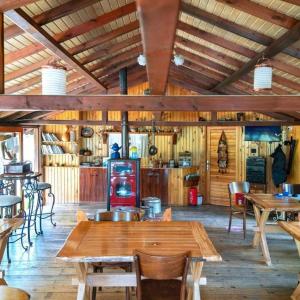 un restaurante con mesas y sillas de madera y una cocina en Abant Korudam bungalov butik otel, en Abant