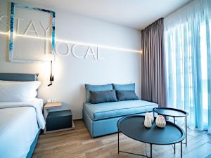 um quarto de hotel com uma cama e um sofá em Local Urban Living em Volos