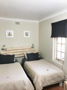 1 Schlafzimmer mit 2 Betten und einem Fenster in der Unterkunft Boskloof Swemgat in Clanwilliam