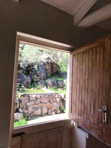 ein Fenster in einem Zimmer mit einer Steinmauer in der Unterkunft Boskloof Swemgat in Clanwilliam