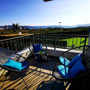 a balcony with three chairs and a table with blue pillows at Villa Black&White in Kastel Sucurac