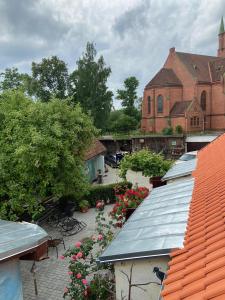 a group of roofs with flowers and a building at Lauma in Kuldīga