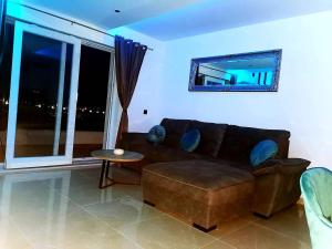 a living room with a brown couch and a table at Villa Black&White in Kastel Sucurac