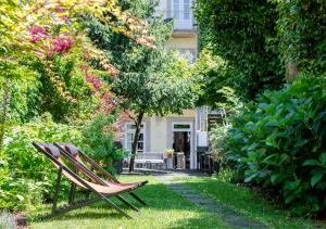 un banco sentado en el césped en un jardín en Rosário Suites Townhouse, by Oporto Collection, en Oporto