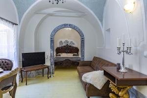 uma sala de estar com um sofá e uma cama em Apartman Charlotte v dome so studňou na streche em Banská Štiavnica