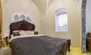 - une chambre avec un grand lit et une tête de lit en bois dans l'établissement Apartman Charlotte v dome so studňou na streche, à Banská Štiavnica