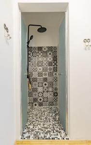 La salle de bains est pourvue d'une douche et d'un mur carrelé. dans l'établissement Apartman Charlotte v dome so studňou na streche, à Banská Štiavnica