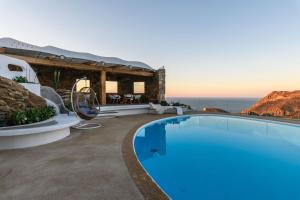 a villa with a swimming pool with a view of the ocean at Villa Aegean Lighthouse in Fanari