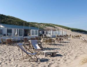 plaża z krzesłami i stołami na piaszczystej plaży w obiekcie Zandvoortferienwohnungen w Zandvoort