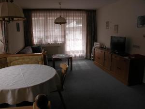 een woonkamer met een tafel en een televisie bij Ferienwohnung Kaufmann in Schladming