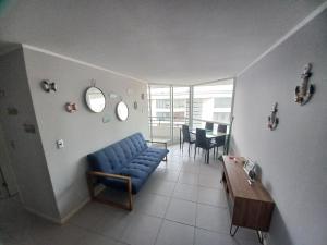 - un salon avec un canapé bleu et une table dans l'établissement vista playa los molles, à Los Molles