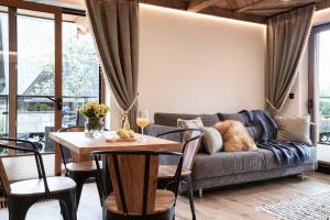 a living room with a couch and a table at Apartamenty Koziniec in Zakopane