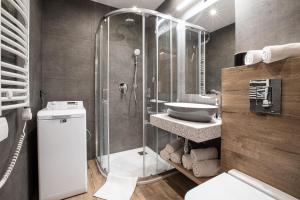 a bathroom with a glass shower and a sink at Apartamenty Koziniec in Zakopane