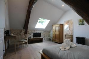 a bedroom with a bed and a desk and a tv at Le Clos Ligérien in Nevers