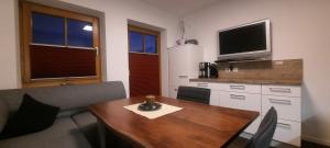 a kitchen with a wooden table and a tv on the wall at Appartement Thunhart Wilfried&Elisabeth in Altenmarkt im Pongau