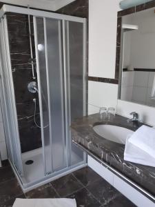 a bathroom with a glass shower and a sink at Gasthof Weißkugel in Vent