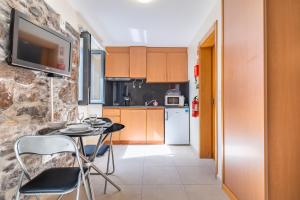 a kitchen with a table and chairs in a room at Casa do Calhau in Jardim do Mar