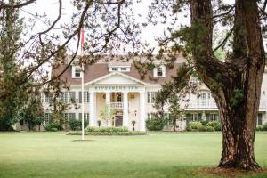 a large house with a flag in front of it at Riverbend Inn & Vineyard in Niagara on the Lake