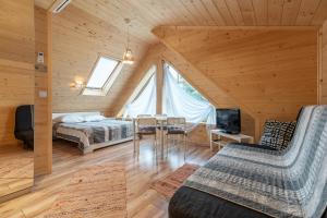 a bedroom with a bed and a table and chairs at Stachelisko - domki i pokoje in Chochołów