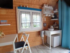 a small kitchen with a desk and a window at Tinyhouse am Fluss in Otterndorf
