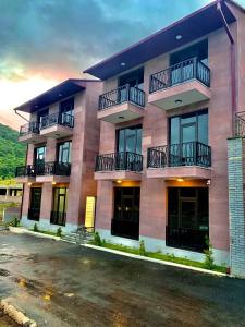 an apartment building with balconies and a parking lot at Harmony Resort in Tsaghkadzor