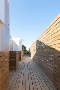 a wooden walkway with a retaining wall on a house at Píllaras da Lanzada in A Lanzada