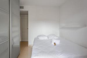 a white bed with towels and a bottle on it at Appartement Californie - Welkeys in Nice