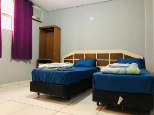 1 dormitorio con 2 camas y sábanas azules en Hotel Praça Orione, en São Paulo
