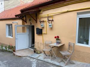 a table and chairs next to a building with a door at Brick Wall in Sibiu
