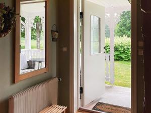 una puerta que conduce a un porche con espejo en 8 person holiday home in VIRESTAD, en Virestad