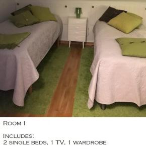 two beds in a room with a green carpet at En trappa upp in Malmö
